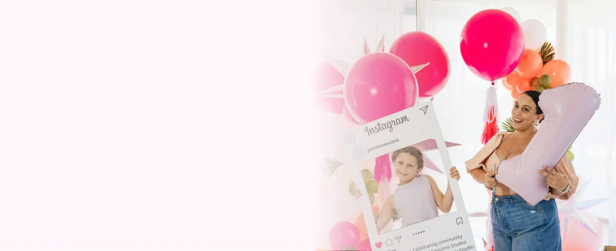 Woman holding a baby shower invitation with pink balloons in the background  DIY Balloon Garland Kits that look like you hired help